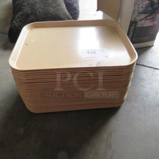 Stack of beige 18x14 lunch trays in used condition, with label displaying number 138.