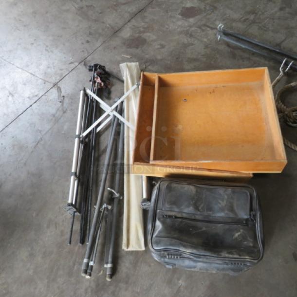 Assorted lot including metal tripods, wooden trays, and a black carrying case. Items appear used. Useful for various projects.
