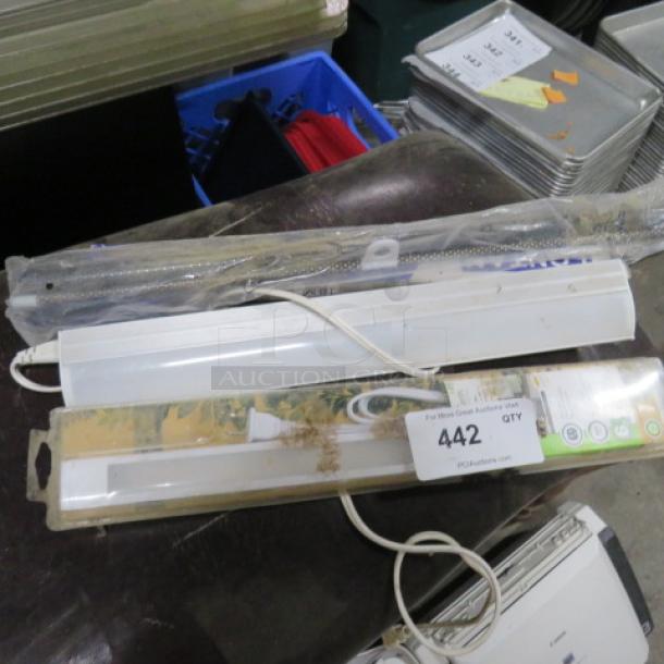 Mixed lot of various light fixtures and hardware, some in original packaging. Includes white light strip with cord. Auction tag 442 visible.
