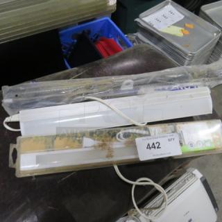 Mixed lot of various light fixtures and hardware, some in original packaging. Includes white light strip with cord. Auction tag 442 visible.