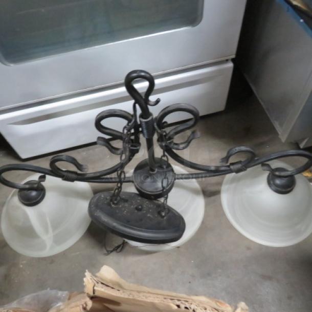 Assorted lighting lot with a metal chandelier featuring three frosted glass shades. Black wrought iron design, used condition.