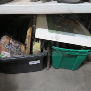 One lot of miscellaneous items including boxes, game board, and poster, stored on a shelf. Condition appears used.