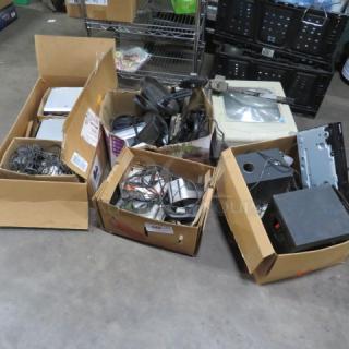 Boxes filled with assorted electronics and cables, includes various devices and accessories. Items in mixed condition.