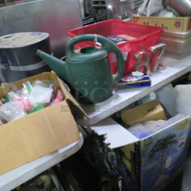 Lot of miscellaneous items including a green watering can, red bin, number decor, and assorted boxes; visible wear and varied materials.