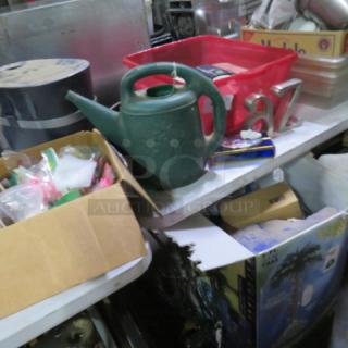 Lot of miscellaneous items including a green watering can, red bin, number decor, and assorted boxes; visible wear and varied materials.