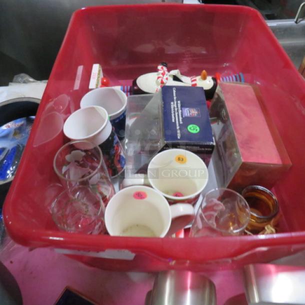 Red bin with assorted items including mugs, glasses, figurines, and boxes. Items have colored price stickers. Various conditions.