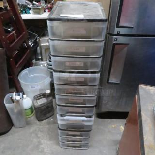 Stack of transparent poly organizer drawers, 10 units, labeled for contents. Used condition, suitable for storage.
