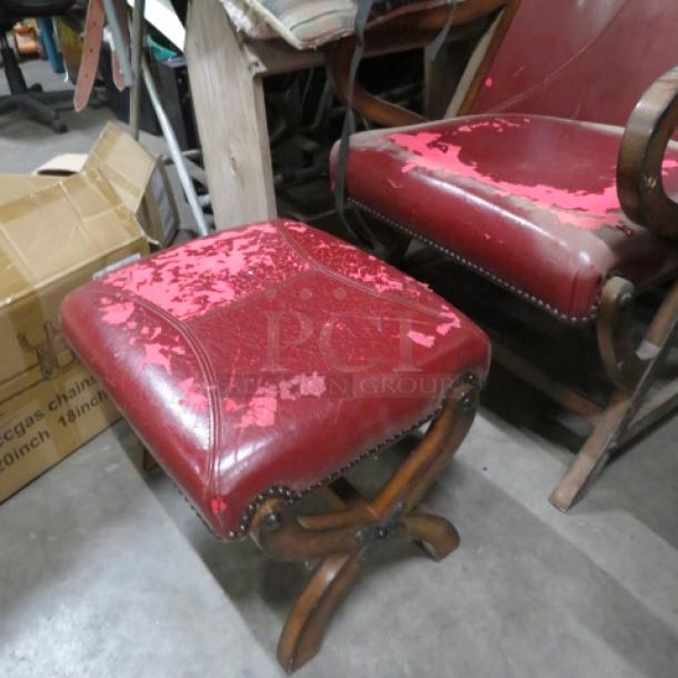 Vintage leather chair with ottoman, red, visible wear, wooden frame. Antique design with decorative nailhead trim.