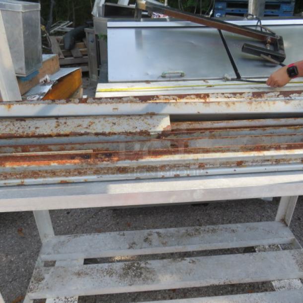 Lot of pallet racking beams, showing signs of rust and wear, suitable for industrial storage needs.