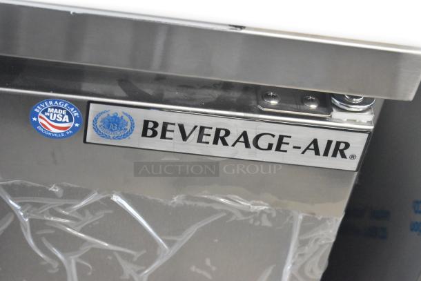 Brand new Beverage Air SPE27HC-B stainless steel prep table, with "Made in USA" label, showing minor scratches.