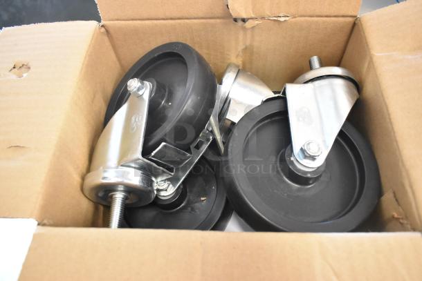 Box of black and metal casters for assembly, shown in an open cardboard box. Part of the Master-Bilt FLR-80 unit.