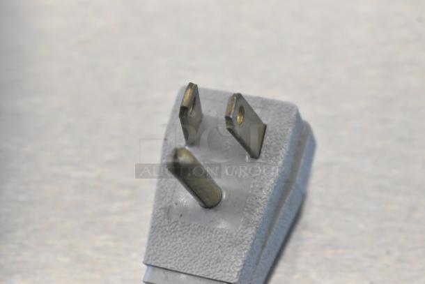 Close-up of a power plug for the True TUC-27D-2-HC undercounter cooler, 115V, 1 phase, showing prongs and texture.