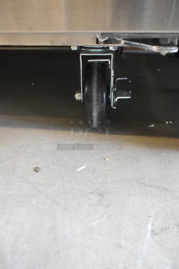 Brand new Avantco 178SSPT6010 2-door refrigerated prep table, visible caster wheel, stainless steel, some scratches.