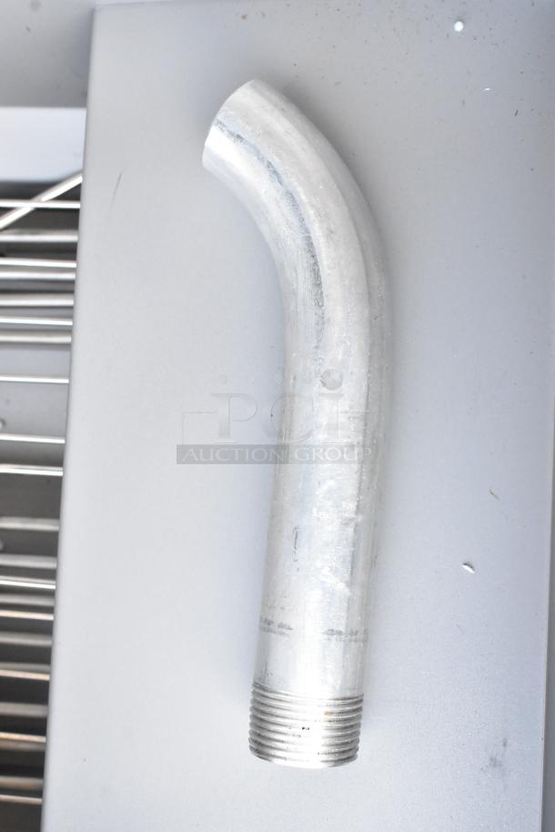 Curved metal pipe on a stainless steel surface; shows threads on one end.