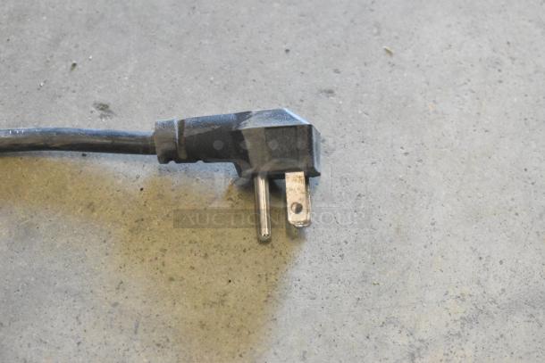 A metal power plug for Premium PRF90DX cooler, 115 Volts, 1 Phase, shown on a concrete floor.