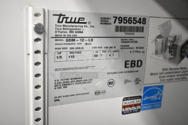 True GDM-12-LD cooler label showing model, 115 volts, 1 phase, suitable for outdoor use, NSF certified.