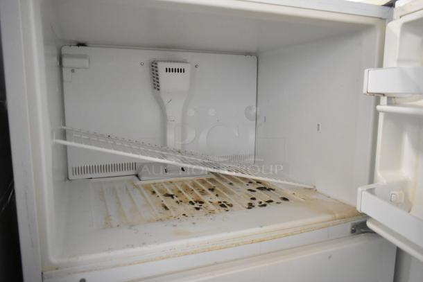 Whirlpool ET1MHKXMQ06 metal reach-in cooler with freezer, 115 volts, 1 phase, interior shows wear and staining, needs cleaning.