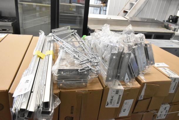 Lot of 9 items, including new scratch and dent chrome finish shelf brackets, packaged and labeled on boxes.