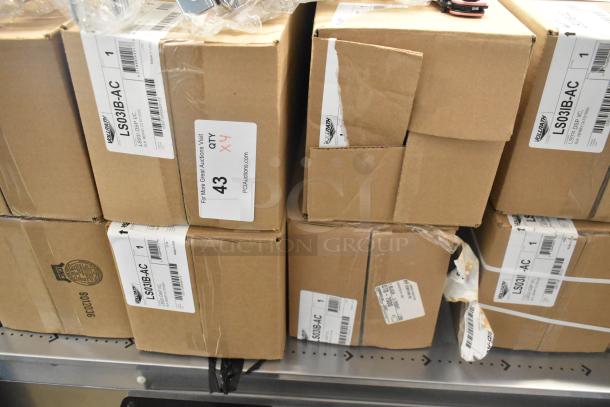 Four new Vollrath LS03IB-AC LidSaver™ 3 in-counter lid dispensers, scratch and dent condition, for 3 1/4" - 3 3/4" lids. Box labels visible.