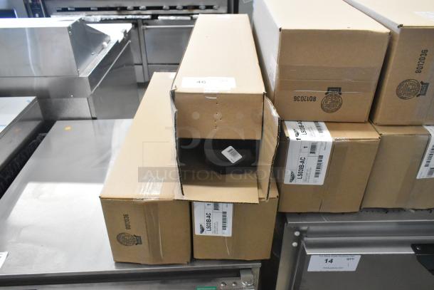 Image showing stacked boxes of Vollrath LS03IB-AC LidSaver™ 3 in-counter horizontal lid dispensers, brand new, for 3 1/4" - 3 3/4" lids.