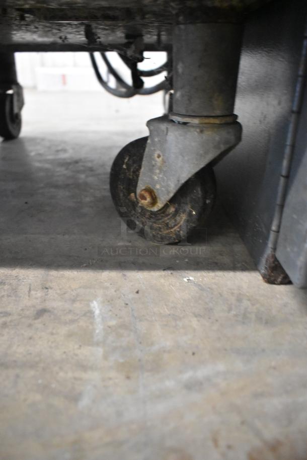Taylor 441-33 ice cream machine caster showing wear, on a concrete floor, highlighting mobility feature.
