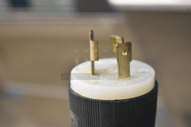Close-up of a power plug for a Taylor 441-33 ice cream machine, showing metal prongs and black casing.