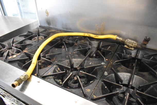 Stainless steel Garland SunFire commercial gas range with 10 burners, two ovens, overshelf, and backsplash. Used condition.