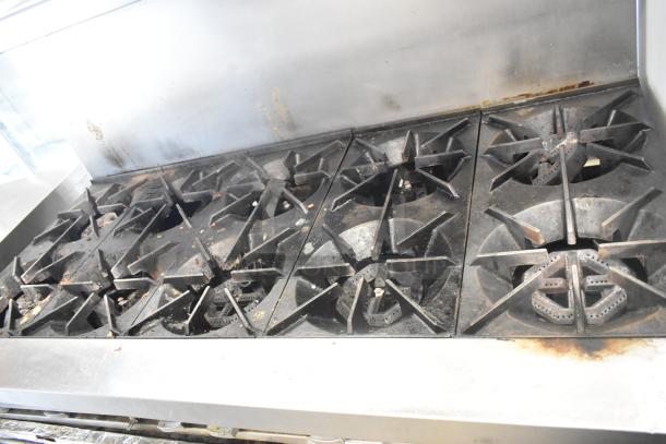 Garland SunFire stainless steel commercial gas range with 10 burners, 2 ovens, over shelf, and backsplash; light wear.