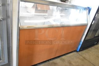 Metal commercial ice cream dipping cabinet with bucket collars, glass front, wood paneling, and stainless steel trim. Good condition.