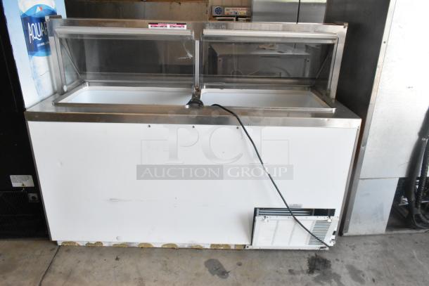 Metal commercial ice cream dipping cabinet with bucket collars, glass top, and power cord. Visible signs of use.