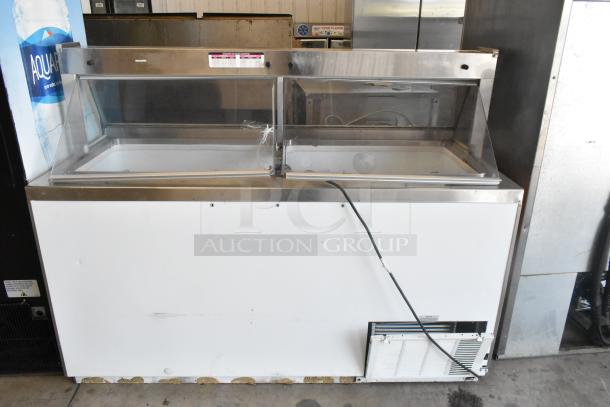 Metal commercial ice cream dipping cabinet with bucket collars, stainless steel finish, used condition, visible temperature controls.