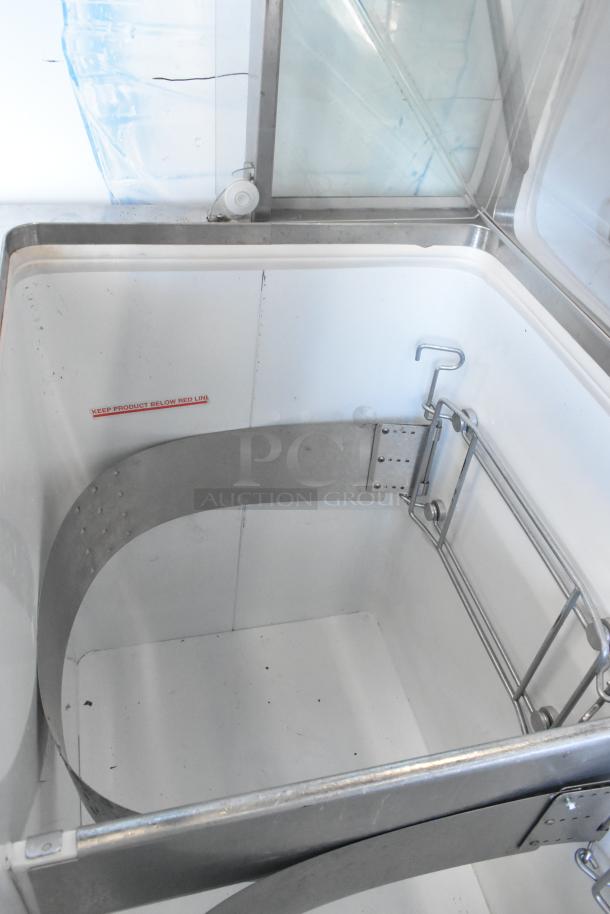 Metal commercial ice cream dipping cabinet with bucket collars, stainless steel finish, interior view showing storage space.