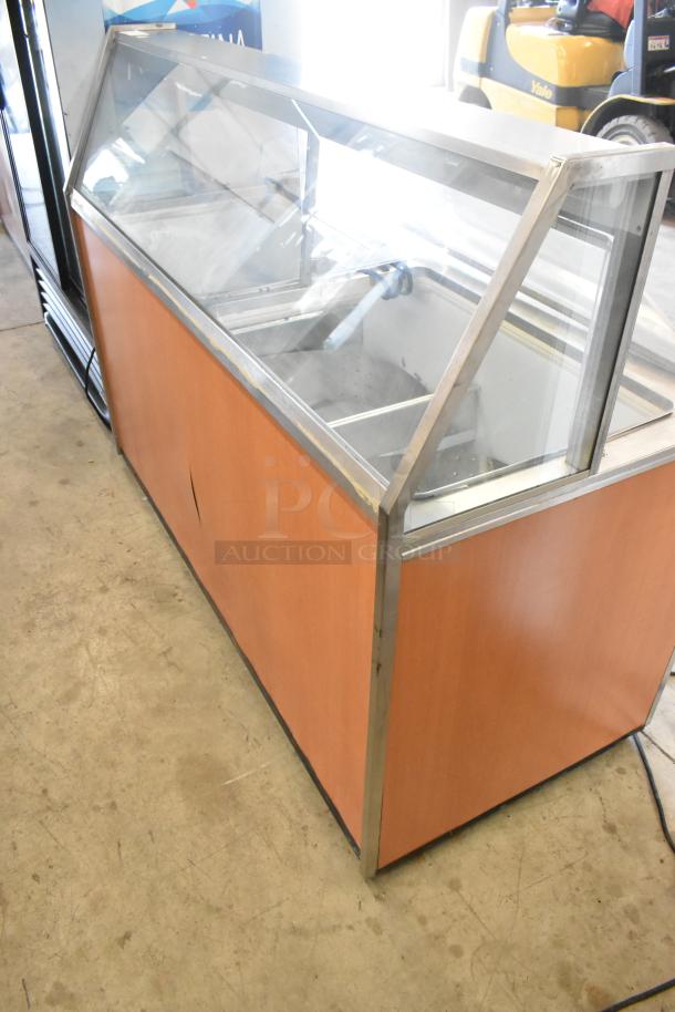 Metal commercial ice cream dipping cabinet with bucket collars, wooden paneling, glass top. Used condition.