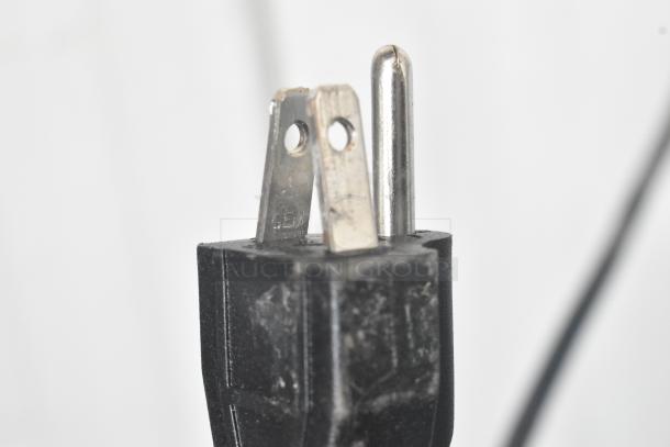 Close-up of a three-prong electrical plug for the Avantco 193HAC28W air curtain merchandiser, showing prongs and black casing.