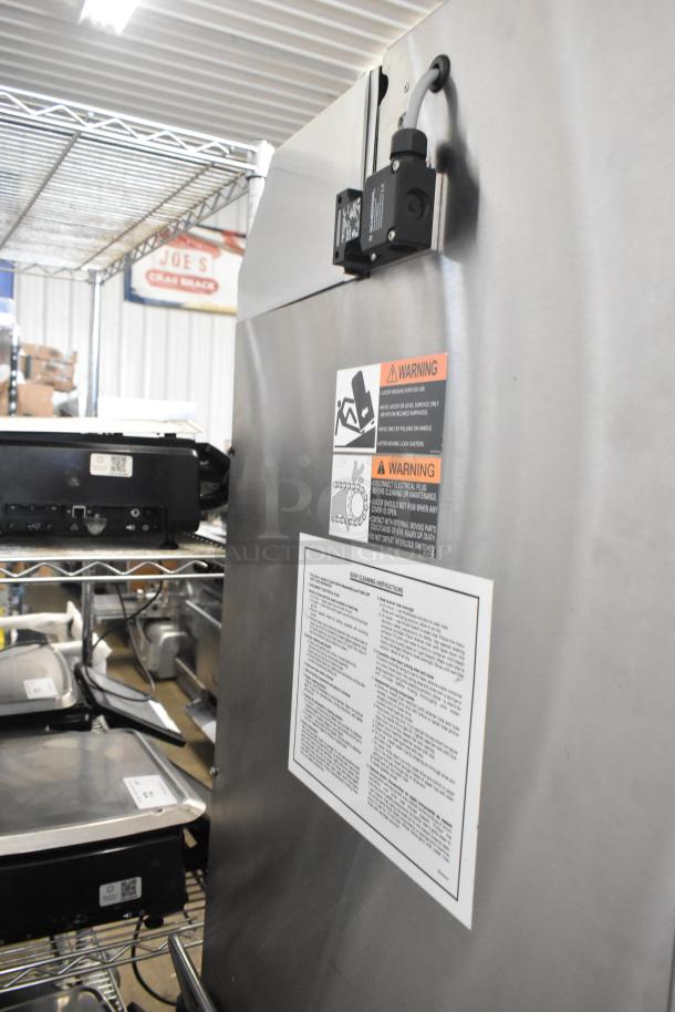 Fresh N Squeeze POS-1 citrus juicer in stainless steel, with commercial casters. Features voltage and phase details, warning labels.