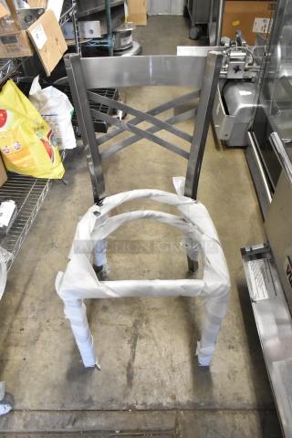 Brand new gray metal dining chair frame with cross back design, partially wrapped. Scratch and dent condition.