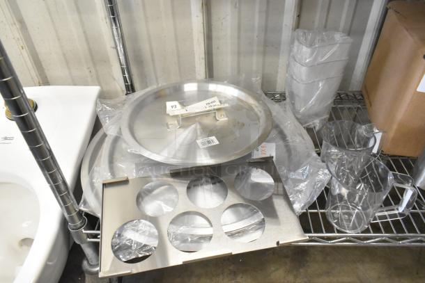 Brand new 471SPC20 aluminum pot cover, poly pitchers, and various items on a metal shelf. Tags indicate model and details.
