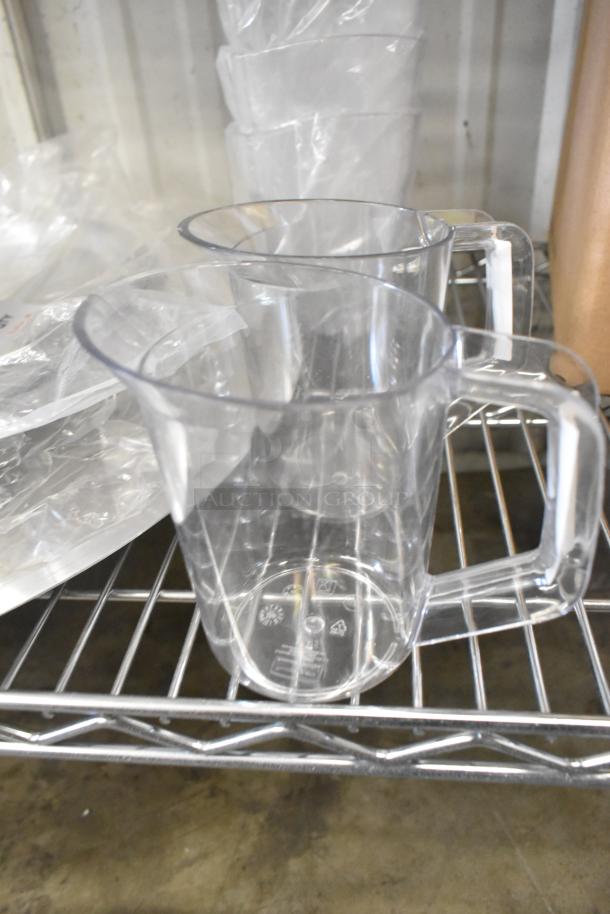 Clear poly pitchers on a shelf with plastic packaging. Part of a scratch and dent auction lot. Brand new condition.