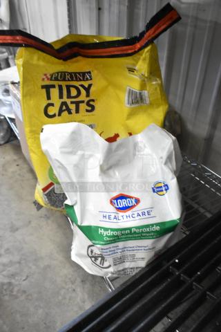 Two bags: Clorox Hydrogen Peroxide Cleaning Wipes and Purina Tidy Cats Litter, unopened, on a metal shelf.