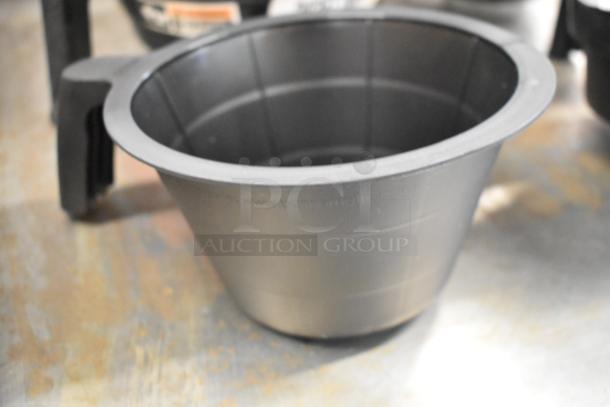 Set of 4 black poly brew baskets in new condition, ideal for coffee makers. Includes handle for easy use. Marked with website URL.