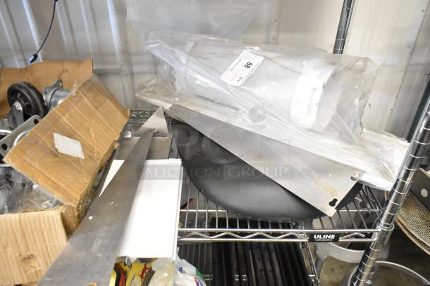 Lot of various items including metal brackets, set cushion, and boxed casters on a metal shelf. Item labeled 88.