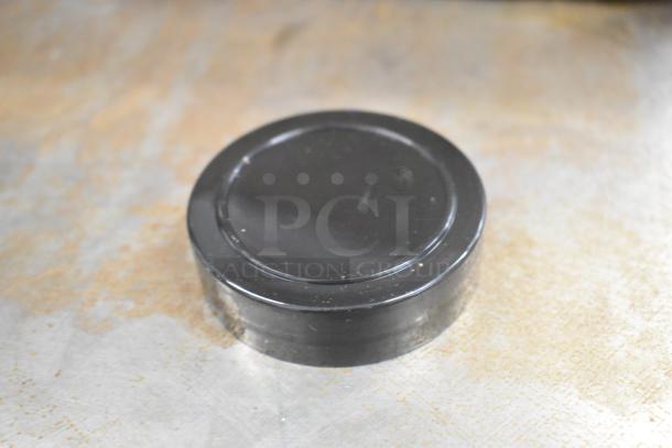 Box of black plastic lids, round shape, in good condition, suitable for jars or containers.