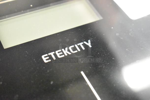Etekcity EB9380H digital scale, black surface, clear display, minor surface wear, brand logo visible.