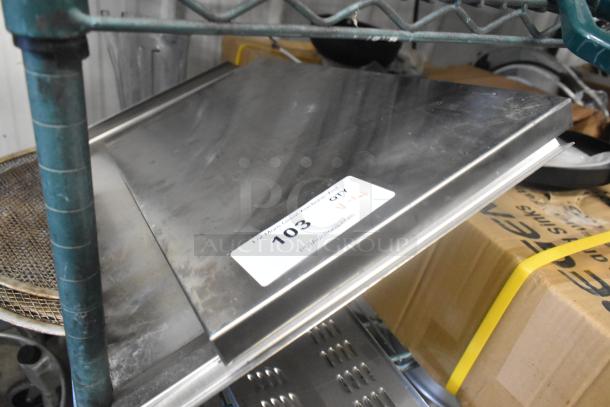Lot of metal panels stacked on a shelf. Visible tag labeled "103" with auction details. Panels appear in used condition.