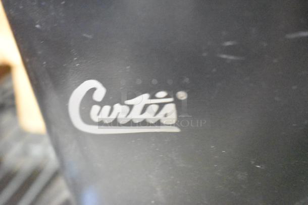 Curtis black poly countertop stand, featuring white "Curtis" logo, in good condition. Ideal for retail or kitchen use.