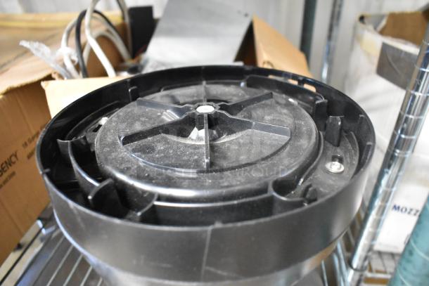 Curtis black poly countertop stand, round base, slightly dusty, visible screws, suitable for commercial use.