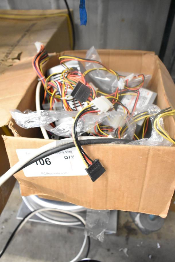 AT-265SFX Power Supply in open box with multiple cables. Item label visible, marked “106” for auction tracking.