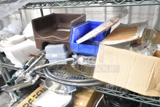 Lot of assorted items on a shelf including a brown booster seat, blue plastic bins, spray nozzle attachment, and cardboard box.