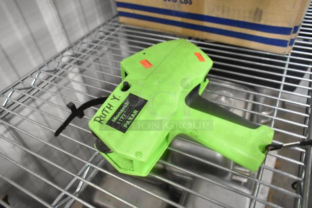 Monarch 1177 price gun, lime green, "Ruth Y." label, on metal shelf. Excellent condition, used for tagging prices.
