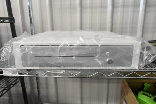 Brand new Clover D100 white metal cash drawer, scratch and dent condition, wrapped in protective plastic, on metal shelf.